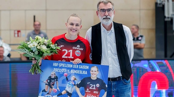 Andreas Thiel, Vorsitzender der Handball Bundesliga, überreicht Annika Lott, Thüringer HC, die Auszeichnung als HBF-Spielerin der Saison 2022/23.