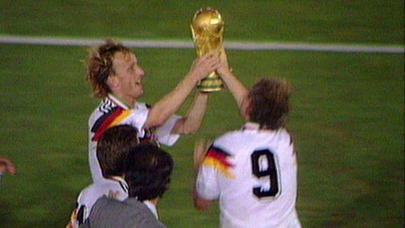 Andreas Brehme 1990 beim WM-Sieg über Argentinien mit einem Pokal in der Hand