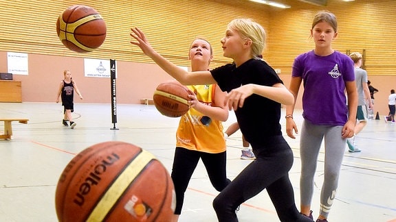 Mädchen trainieren Korbwürfe bei einem Basketball-Feriencamp.