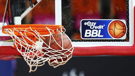 Basketball fliegt in den Korb vor Logo BBL Basketball Bundesliga