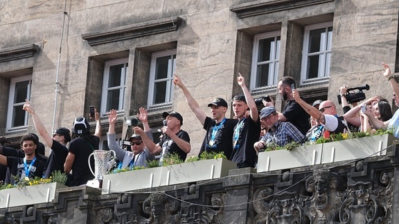 Spieler des Basketballteams Niners Chemnitz stehen feiernd auf dem Balkon des Rathauses. Die Mannschaft der Niners Chemnitz wurde von mehreren Tausend Fans nach dem Sieg im Finale des FIBA Europe Cup gegen Bahcesehir Koleji gefeiert.