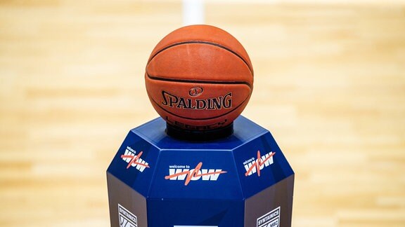 Ein Basketball auf einem blauen Sokkel