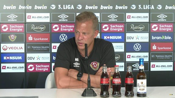 Dresden-Trainer Markus Anfang vor einer Werbebande auf einer Pressekonferenz