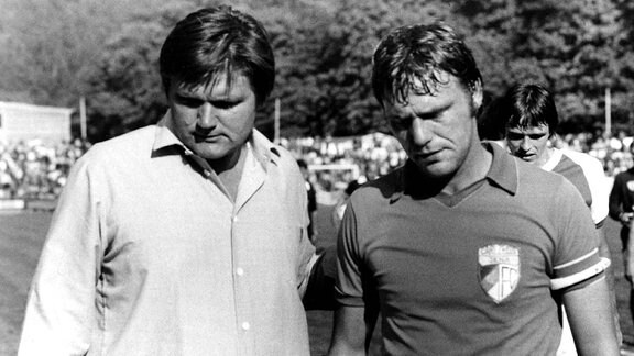 Hans Meyer, Trainer des FC Carl Zeiss Jena (li.) mit seinem Kapitän Rüdiger Schnuphase enttäuscht nach einem Spiel in der Saison 1983/1984