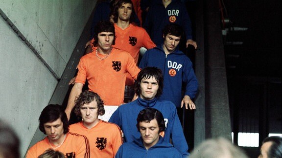 Die Mannschaften der DDR und Niederlande auf dem Weg ins Gelsenkirchener Parkstadion bei der WM 1974. Jürgen Pommerenke steht auf der Rolltreppe zwischen Reinhard Lauck (vorn/BFC Dynamo und 1. FC Union Berlin) und Wolfram Löwe (hinten/1. FC Lok Leipzig).