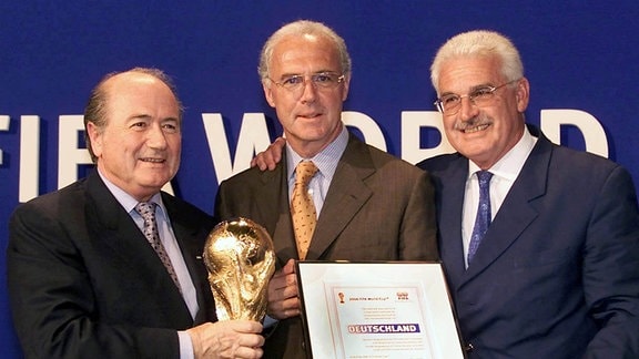 Weltmeisterschaft 2006 Strahlende Gewinner: Franz Beckenbauer(mitte) und Fedor Radmann (re) bekommen die Ausrichterurkunde von FIFA Chef Joseph S. Blatter