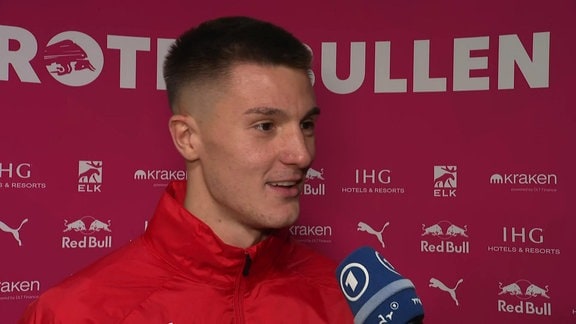 Spieler im Interview vor Werbebande