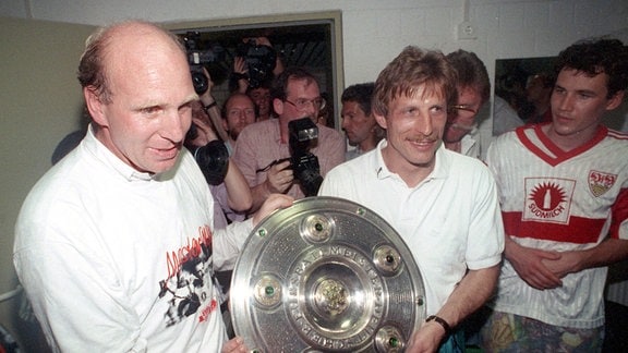 Stuttgarts Manager Dieter Hoeneß (l) und Trainer Christoph Daum zeigen im Leverkusener Ulrich-Haberland-Stadion stolz die eroberte Meisterschale (Archivfoto vom 16.05.1992).