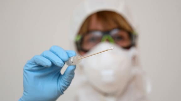 Eine Ärztin hält das Wattestäbchen eines Coronavirus-Tests in der Hand