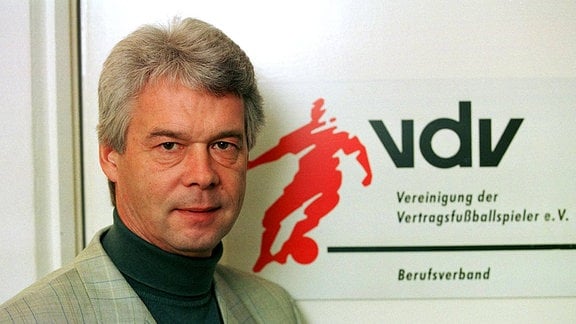 Jürgen Sparwasser vor dem Logo der Vereinigung Fußball 1. BL Herren Saison 1998/1999