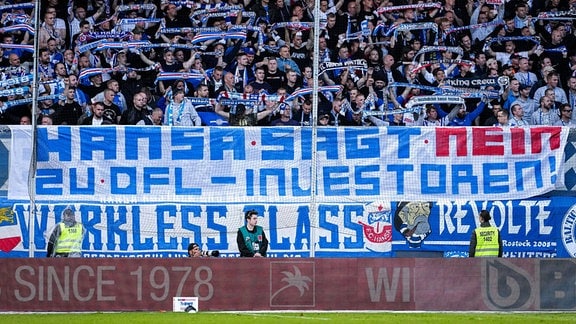 Die mitgereisten Fans vom F.C. Hansa Rostock zeigen ein Banner, Spruchband mit der Aufschrift: «Hansa sagt Nein zu DFL-Investoren»