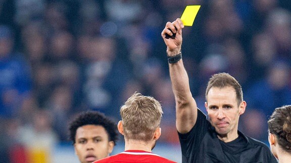 Schiedsrichter Sascha Stegemann, gibt Konrad Laimer, RB Leipzig, die gelbe Karte,