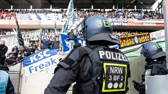 Polizisten stehen vor den Fans von Karlsruher SC