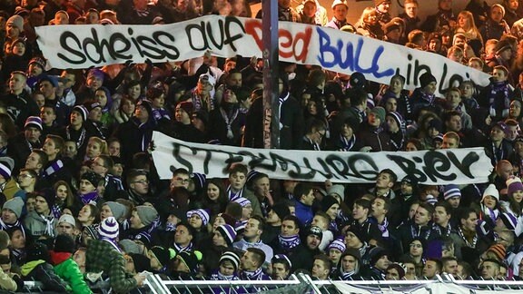 Fans  von Erzgebirge Aue halten ein Banner mit der Aufschrift 'Scheiss auf Red Bull in Leipzig'  