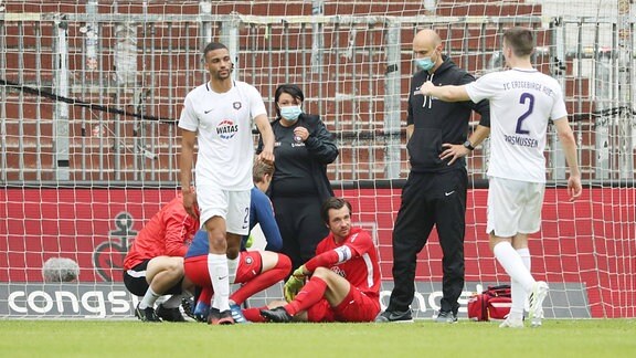 Torhüter Martin Männel (1, Aue) muss wegen einer Schulterverletzung von Physiotherapeutin Marie Koch (Aue) und Teamarzt Stephan Rezmann behandelt werden.