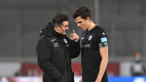 Trainer Christian Titz gibt Tobias Mueller (beide 1. FC Magdeburg) Anweisungen.