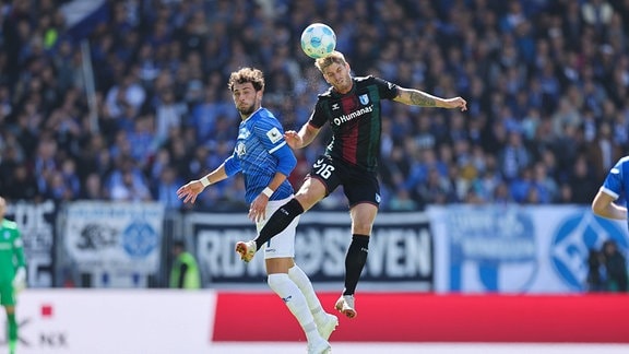 Die Fußballspieler Fraser Hornby (SV Darmstadt 98) und Marcus Mathisen (1. FC Magdeburg) im Kopfballduell