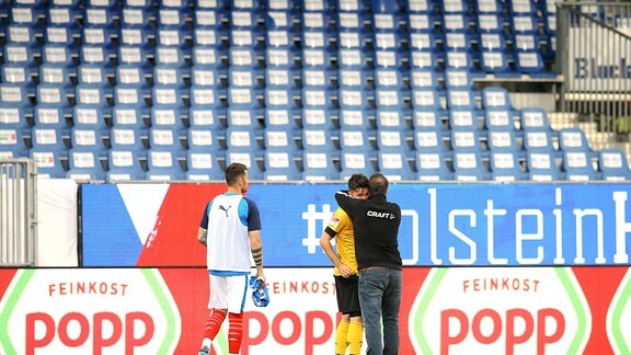 am Boden zerstört ist nach dem Schlusspfiff der Dresdner Spieler Niklas Kreuzer hier umarmt von Trainer Kauczinski 
