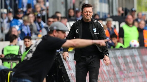 Trainer Christian Titz (1. FC Magdeburg) und unscharf Trainer Steffen Baumgart (Hamburger SV)