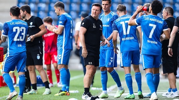 Trainer Christian Titz umringt von seinen Spielern des 1. FC Magdeburg