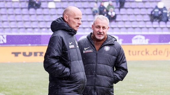 Sportdirektor Matthias Heidrich, Erzgebirge Aue, und Trainer Pavel Dotchev, Erzgebirge Aue unterhalten sich a Spielfeldrand.