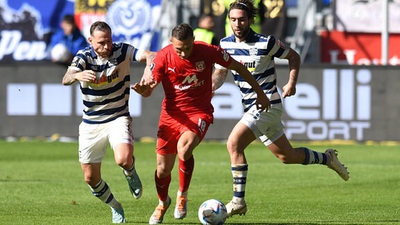 Marvin Bakalorz links MSV Duisburg und Marlon Frey rechts MSV Duisburg nehmen Dominik Steczyk Hallescher FC in die Zange. 