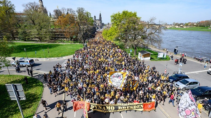 Anhänger der SG Dynamo Dresden nehmen an einem Fanmarsch zum Stadion teil und laufen am Terrassenufer entlang.