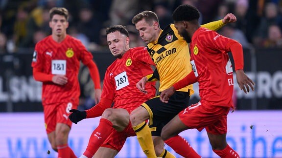 Dynamos Niklas Hauptmann (2.v.r.) gegen Dortmunds Falko Michel (2.v.l.) und Rodney Elongo-Yombo (r).