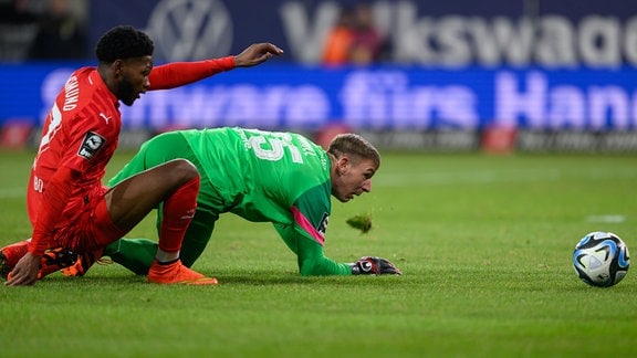 Dynamo Dresdens Torwart Kevin Broll (r) kann das Tor zum 0:1 durch Borussia Dortmunds Rodney Elongo-Yombo nicht verhindern.