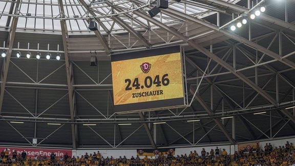 Eine Anzeige in einem Fußballstadion zeigt die Anzahl der Zuschauer*innnen an.