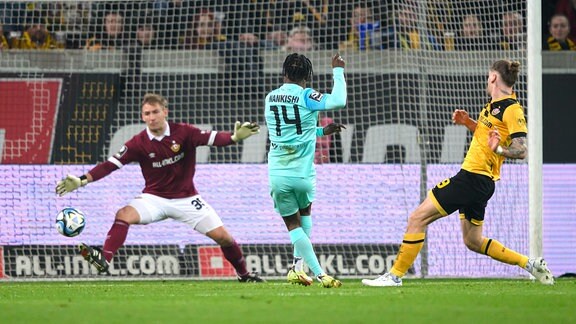 Münchens Abdenego Nankishi erzielt gegen Dynamos Torwart Torwart Kevin Broll und Kevin Ehlers das Tor zum 1:1