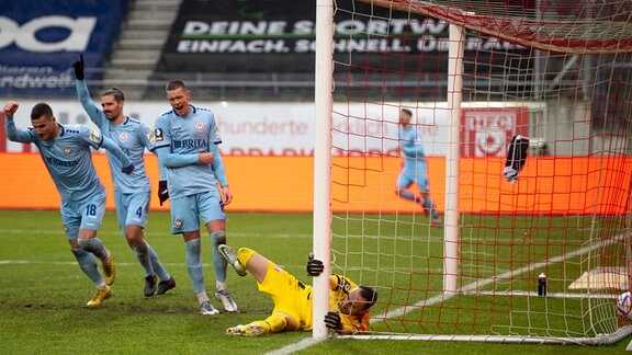 Hallescher FC vs. SV Wehen Wiesbaden Bjarke Jacobsen Wiesbaden jubelt nach seinem Tor zum 0: 3 mit Ihm jubeln v.li. Ivan Prtajin Wiesbaden und Sascha Mockenhaupt Wiesbaden. Torhüter Felix Gebhardt Hallescher FC kann das Tor nicht verhindern.