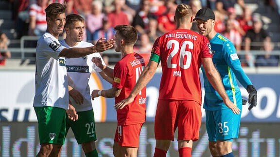 Sebastian Mai, HFC und Patrick Göbel, HFC, diskutieren mit den Gegenspielern von Preußen Münster über die Torentscheidung zum 2:2.