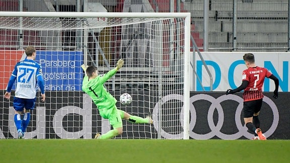 Dennis Eckert Ayensa (FC Ingolstadt) erziehlt das Tor zum 1:0. Morten Behrens (1.FC Magdeburg) kann nicht halten