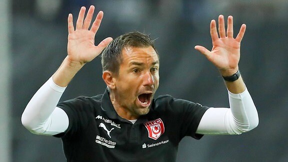 Trainer Andre Meyer (Hallescher FC) ruft mit erhobenen Händen