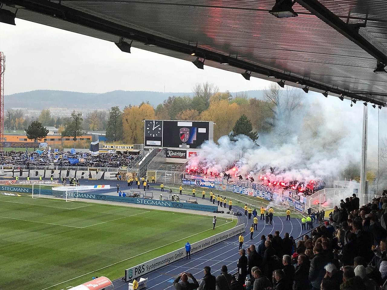 Brennende Pyrotechnik im Fanblock von Hansa Rostock beim Spiel gegen FC Carl Zeiss in Jena