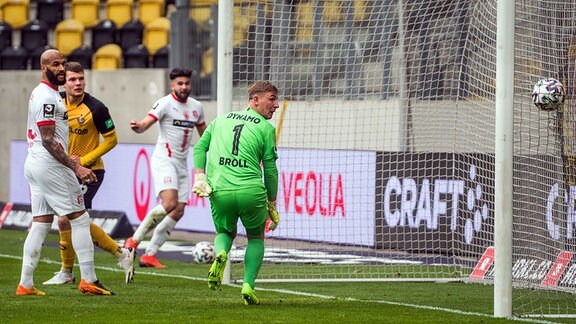 Der Ball landet zum 0:1 im Tor von Dynamo, Torwart Kevin Broll kann nur noch zuschauen.