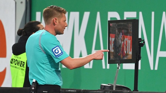 Schiedsrichter Christian Dingert vor einem Monitor
