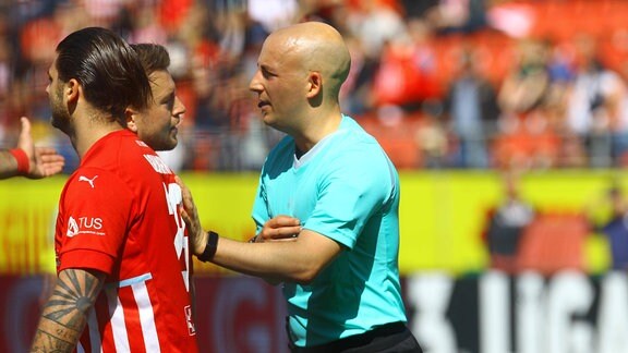 Schiedsrichter Nicolas Winter Hagenbach diskutiert mit Patrick Göbel Zwickau nach dem umstritenen Elfmeterpfiff, vorne Dominic Baumann Zwickau