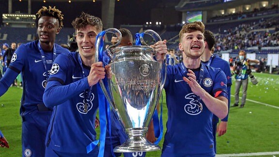 Kai Havertz und Timo Werner von Chelsea halten den UEFA Champions League  Pokal triumphierend in die Kameras der Journalisten, 2021