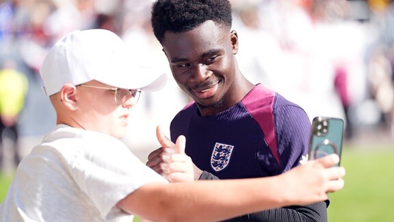 Bukayo Saka (rechts) macht ein Foto mit einem Fan.