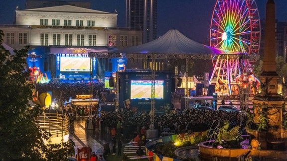 Blick auf die beleuchtete Fanzone in Leipzig bei Nacht.