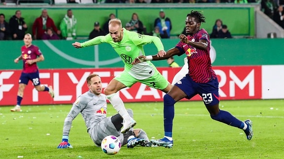 Vaclav Cerny (VfL Wolfsburg,7) gegen Castello Lukeba (RB Leipzig,23) und Torwart Peter Gulacsi (RB Leipzig,1)