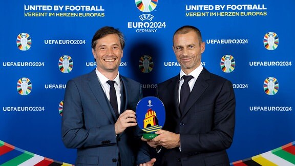 Heiko Rosenthal, Bürgermeister der Stadt Leipzig und Aleksander Ceferin, UEFA President, halten gemeinsam das Euro 24-Logo, 2021