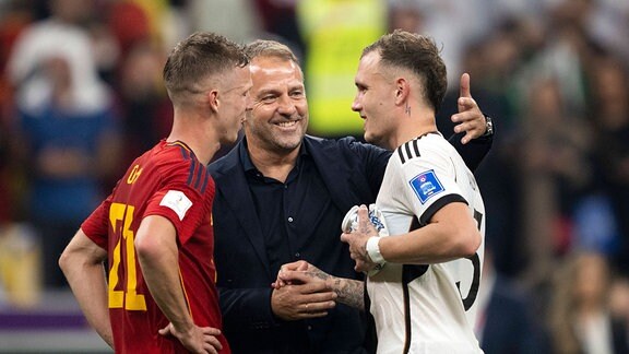 Hansi Flick unterhält sich mit Dani Olmo aus Spanien und David Raum aus Deutschland nach dem FIFA World Cup WM Gruppe E-Spiel zwischen Spanien und Deutschland im Al Bayt Stadium