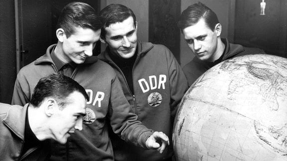 Die DDR-Spieler (v.l.) Helmut Stein, Fritz Feister, Wolfgang Blochwitz und Bernd Bransch studieren am 13.01.1967 in Berlin den Globus. Die DDR-Fußballnationalmannschaft geht in zwei Tagen auf Afrika-Reise.