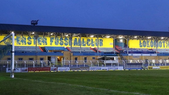 Bruno-Plache-Stadion, Heimstatt des 1.FC Lokomotive Leipzig. Leere, beleuchtete Tribüne zur blauen Stunde.