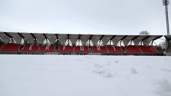 RWE hat die Fans gebeten, bei der Schneeräumung im Stadion zu helfen, die freiwilligen Helfer kämpfen sich durch die Schneemassen und transportieren den Schnee mit Folien vom Platz