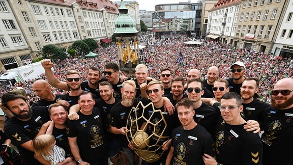 Die Magdeburger Spieler und Trainer präsentieren auf dem Rathausbalkon die Champions-League-Trophäe.