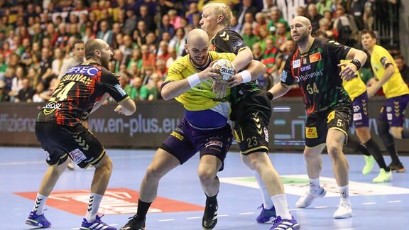 Die Handballspieler Christian O Sullivan (Magdeburg, 24), Artsem Karalek (Kielce, 50) und Magnus Saugstrup (Magdeburg, 23) im Kampf um den Ball